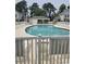 Community pool surrounded by lounge chairs, a covered seating area, and manicured lawns at 102 Scotch Broom Dr. # B-204, Little River, NC 29566