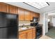 Compact kitchen featuring wood cabinets, granite countertops, and black appliances at 1105 S Ocean Blvd. # 110, Myrtle Beach, SC 29577