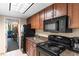 Compact kitchen with wood cabinets, black appliances and granite countertops at 1105 S Ocean Blvd. # 110, Myrtle Beach, SC 29577