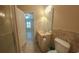 Bathroom with toilet, vanity and mirror and tiled backsplash, located ensuite to the bedroom at 1224 Checkerberry St., Longs, SC 29568
