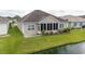 Back exterior of home featuring a screened in porch, landscaped yard, and a pond at 1224 Checkerberry St., Longs, SC 29568
