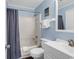 Cozy bathroom with blue walls, a shower-tub combo, toilet, and single sink vanity at 1310 N Waccamaw Dr. # 208, Garden City Beach, SC 29576