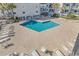 Aerial view of a clean, sparkling pool, surrounded by lounge chairs and palm trees for relaxation at 1310 N Waccamaw Dr. # 208, Garden City Beach, SC 29576