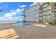 Community pool near the ocean featuring clear water and deck with lounge chairs near the building at 1310 N Waccamaw Dr. # 208, Garden City Beach, SC 29576