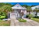 Charming two-story home with pink trim, a white metal roof, landscaped yard, and a two-car garage at 146 Georges Bay Rd., Surfside Beach, SC 29575