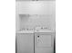 Functional laundry room with a white washer and dryer and wire shelving at 146 Georges Bay Rd., Surfside Beach, SC 29575