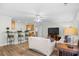 Open-concept living room featuring wood floors, ceiling fan, and an adjacent kitchen with bar seating at 146 Georges Bay Rd., Surfside Beach, SC 29575