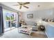 Cozy living room with comfortable seating, ceiling fan, and sliding glass doors to the patio with a green view at 1460 Blue Tree Ct. # E, Myrtle Beach, SC 29588