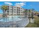 Beautiful community pool with lounge chairs and palm trees at a condo complex under a blue sky with white clouds at 150 Ella Kinley Circle # 301, Myrtle Beach, SC 29588