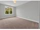 Bright bedroom features a large window and plush carpeting at 1545 Coastal Cove Ln, Calabash, NC 28467