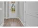 Entryway featuring hardwood floors, a glass-paneled front door, and white trim at 1545 Coastal Cove Ln, Calabash, NC 28467