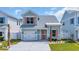 Charming two-story home featuring a single-car garage, light blue siding, and coral window shutters at 1545 Coastal Cove Ln, Calabash, NC 28467