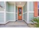A welcoming front entryway featuring a coral-colored door surrounded by light blue and white accents at 1545 Coastal Cove Ln, Calabash, NC 28467