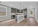 Well-lit kitchen features a central island, stainless steel appliances, and access to a side door at 1545 Coastal Cove Ln, Calabash, NC 28467