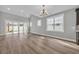 Bright open-concept living room with sliding glass doors and modern lighting at 1545 Coastal Cove Ln, Calabash, NC 28467