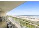Relaxing balcony with seating offers panoramic views of the sandy beach and sparkling ocean at 1625 S Ocean Blvd. # 309, North Myrtle Beach, SC 29582