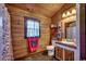 Rustic bathroom with wood paneled walls, and tile flooring. Vanity with a vessel sink and decorative mirror at 181 Halfway Rd., Nichols, SC 29581