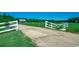 Gated ranch entrance leading to property with a charming home nestled among expansive green fields and mature trees at 181 Halfway Rd., Nichols, SC 29581