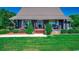 Charming log cabin-style home with a metal roof, landscaped front yard, and inviting porch at 181 Halfway Rd., Nichols, SC 29581