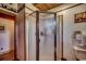 Bathroom featuring a glass enclosed shower with chrome trim adjacent to the toilet and doorway at 181 Halfway Rd., Nichols, SC 29581