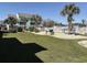 Community pool area with well-maintained lawn, palm trees, and white picket fence at 1930 Bent Grass Dr. # 39H, Surfside Beach, SC 29575