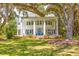 Stately white home featuring a grand front porch with large columns and a manicured lawn shaded by mature trees at 21 Whitehall Ave., Georgetown, SC 29440