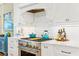 Kitchen detail of stainless steel range and hood, white cabinets, and decorative backsplash at 21 Whitehall Ave., Georgetown, SC 29440