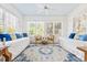 Bright sunroom features twin beds, ceiling fan, white walls, and windows at 21 Whitehall Ave., Georgetown, SC 29440