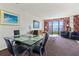 Well-lit living room with a glass table, dining set, comfortable sofas, and balcony access at 2500 N Ocean Blvd. # 102, Myrtle Beach, SC 29577