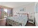 The main bedroom has a bed with bright patterned linens and sliding doors to a balcony at 2500 N Ocean Blvd. # 102, Myrtle Beach, SC 29577