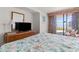 View of a main bedroom with a flatscreen TV, and sliding glass doors leading to a balcony at 2500 N Ocean Blvd. # 102, Myrtle Beach, SC 29577