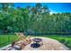 Serene backyard featuring a lounge chair and fire pit overlooking a lush green space and tall trees at 251 Copper Leaf Dr., Myrtle Beach, SC 29588