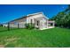 Spacious backyard with a covered patio, outdoor kitchen, and lush lawn enclosed by a black fence at 251 Copper Leaf Dr., Myrtle Beach, SC 29588