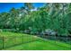 Scenic backyard with lush green grass, mature trees, and a serene water view, framed by a black metal fence at 251 Copper Leaf Dr., Myrtle Beach, SC 29588