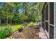 Outdoor patio area with chairs and a grill, surrounded by lush landscaping and mature trees at 260 Dunbarton Ln., Conway, SC 29526