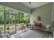 Relaxing screened porch with outdoor seating, offering a peaceful view of the surrounding wooded area at 260 Dunbarton Ln., Conway, SC 29526