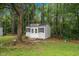 A charming storage shed surrounded by lush greenery and tall trees offers a private and functional outdoor space at 260 Dunbarton Ln., Conway, SC 29526