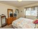 Serene bedroom featuring natural light, a wood dresser, and a comfortable bed with patterned bedding at 305 N Hillside Dr. # 206, North Myrtle Beach, SC 29582