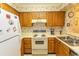 Kitchen with laminate countertops, stainless sink, wooden cabinets and floral wallpaper at 305 N Hillside Dr. # 206, North Myrtle Beach, SC 29582