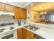 Kitchen with laminate countertops, stainless sink, wooden cabinets and floral wallpaper at 305 N Hillside Dr. # 206, North Myrtle Beach, SC 29582
