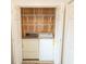 Laundry closet with washer, dryer, wire shelving, and wooden paneling behind folding doors at 305 N Hillside Dr. # 206, North Myrtle Beach, SC 29582
