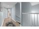 Hallway view featuring light blue walls, light wood floors and a decorative runner with white banister railing and staircase at 3401 N Ocean Blvd. # 110, North Myrtle Beach, SC 29582