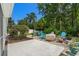 Backyard patio area with chairs, fire pit, mature landscaping, and wooded views at 4 Clemson Rd., Conway, SC 29526