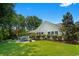 Lush backyard with manicured lawn, trees, and patio seating offers a serene and private outdoor retreat at 4 Clemson Rd., Conway, SC 29526