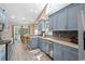 Well-lit kitchen showcasing blue cabinetry, stainless appliances, tile backsplash, and wood floors at 4 Clemson Rd., Conway, SC 29526