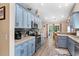 Stylish kitchen with blue cabinets, stainless steel appliances, tile backsplash, and wood flooring at 4 Clemson Rd., Conway, SC 29526