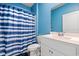 Bright bathroom featuring a white vanity, a toilet, and a shower with a blue and white curtain at 402 Toledo St., Conway, SC 29526