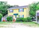 Two story house featuring a yellow exterior, green shutters, and mature landscaping at 404 13Th Ave. S, Myrtle Beach, SC 29577