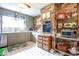 Vintage kitchen showcasing gray cabinets, stainless steel appliances, and unique brick accent wall at 404 13Th Ave. S, Myrtle Beach, SC 29577