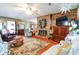 Cozy living room featuring a brick fireplace, hardwood floors, and a decorative ceiling fan at 404 13Th Ave. S, Myrtle Beach, SC 29577